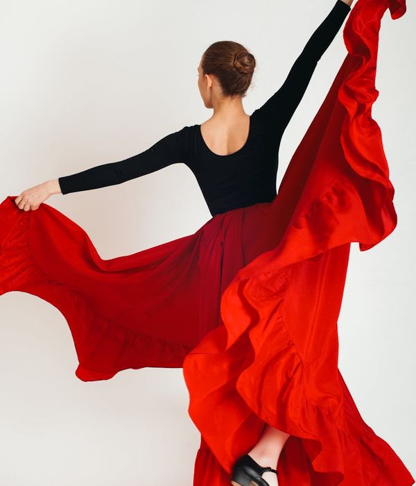 Woman performing a graceful, flowing cardio movement indoors.